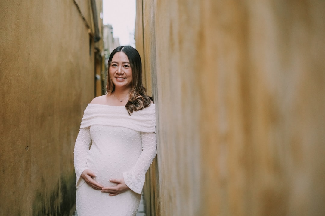 Healthy pregnant woman in white holding her belly