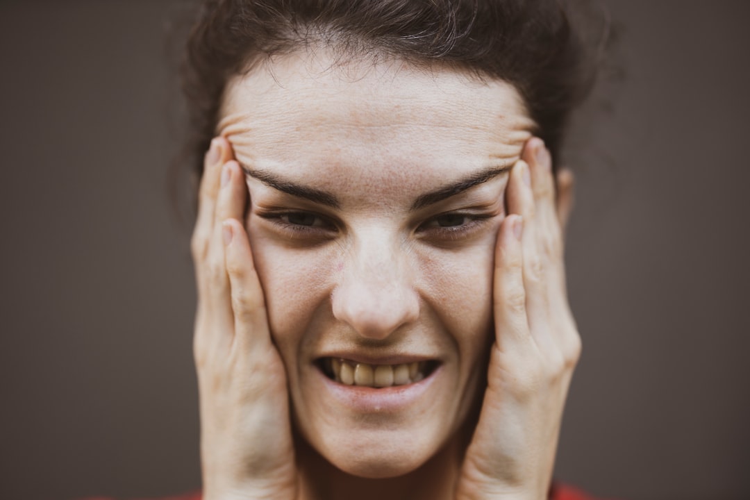 Woman holding her jaw experiencing TMJ pain and discomfort
